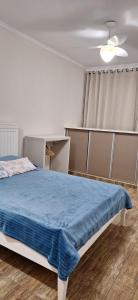 a bedroom with a bed with a blue blanket on it at Apartamento vista mar Santos in Santos