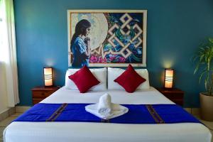 a bedroom with a large bed with a painting on the wall at Los Amigos Hostel in Flores +42 photos