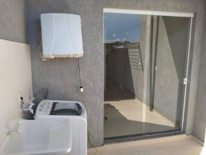 a bathroom with a washing machine and a window at Sobrado novo - Oktoberfest in Blumenau