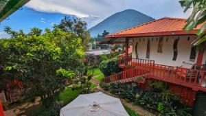 a house with an umbrella and a mountain in the background at 1961 Los Naranjos Hostal in Los Naranjos