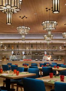 a restaurant with tables and chairs and chandeliers at PARKROYAL Langkawi Resort in Pantai Cenang
