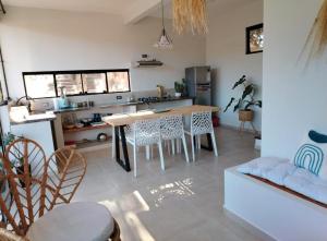 a kitchen and living room with a table and chairs at Prana Cabaña Kira 3 hab in Samaipata