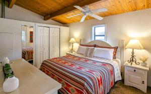 a bedroom with a bed and a ceiling fan at Mama Bears Cabin in Ruidoso