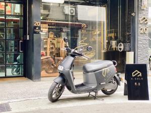 uno scooter parcheggiato su un marciapiede di fronte a un negozio di K. Gold a Taichung