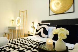 a bedroom with a bed with a vase with flowers at Luton Airport House, Opposite airport staff parking in Luton