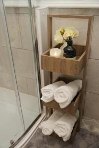 a towel rack with towels and a vase with flowers at Luton Airport House, Opposite airport staff parking in Luton
