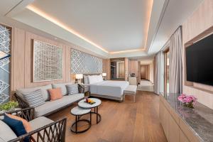 a living room with a couch and a television at Henann Premier Coast Resort in Panglao +26 photos