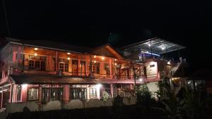 una casa iluminada por la noche con luces en Judita Cottages, en Tuk Tuk