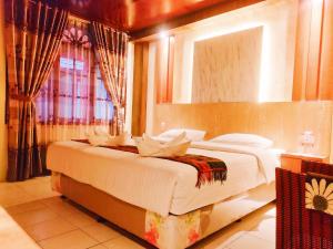 Un dormitorio con una cama grande con espejo. en Judita Cottages, en Tuk Tuk