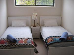 two beds sitting next to each other in a bedroom at St Helens Beachfront in Edithburgh
