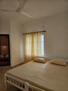 a large bed in a bedroom with a window at White House Homestay in Cochin