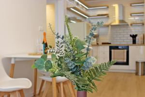 a vase filled with plants in a living room at NOVERA Apartments #24 in Turčianske Teplice
