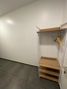 a closet with a white wall and wooden shelves at Aviators Guest House - Premium Room in Strausberg