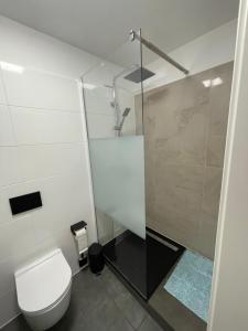a white bathroom with a toilet and a shower at Aviators Guest House - Premium Room in Strausberg