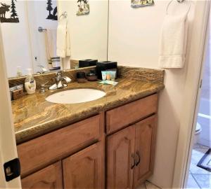 a bathroom with a sink and a mirror at Pinecliff Retreat in Ruidoso +25 photos