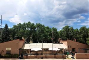 a building with tables and white umbrellas at Pinecliff Retreat in Ruidoso