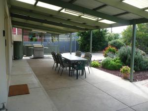 eine Terrasse mit Tisch und Stühlen unter einer Pergola in der Unterkunft Jetty Views in Wauraltee