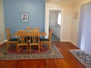 ein Esszimmer mit einem Holztisch und Stühlen in der Unterkunft Jetty Views in Wauraltee