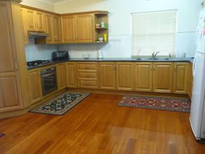 eine Küche mit Holzschränken und Holzböden in der Unterkunft Jetty Views in Wauraltee