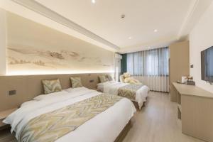 duas camas num quarto de hotel com um urso de peluche sentado em cima em 乌镇闲情逸致精品民宿 em Wujiaqiao