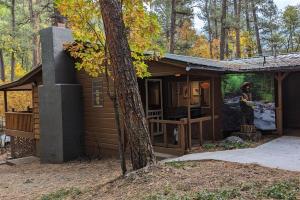 a small cabin in the woods with a tree at Ruidoso River Trail Cabin in Ruidoso