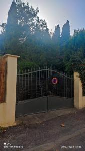 a gate in front of a mountain with trees at Eco-refuge la Nuit étoilée, Calme, Wifi,5 mn Centre à pied, parking gratuit, parking vélo in Arles