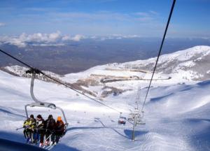 a group of people riding a ski lift in the snow at Miletto Holiday House in San Massimo