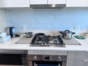a kitchen stove with pots and pans on it at New condo near Lougheed Mall & SFU in Coquitlam