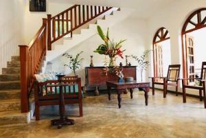 a living room with a staircase and a table and chairs at Coastal Cloud Backpackers in Unawatuna