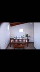 a living room with a bench and a plant at Coastal Cloud Backpackers in Unawatuna