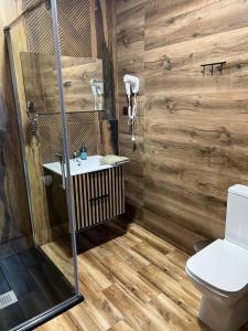a bathroom with wooden walls and a toilet and a sink at Vrbecká restaurace - penzion 10 in Hrubá Vrbka