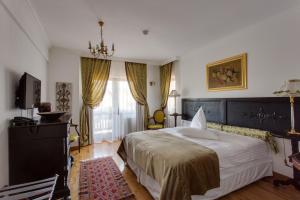 a bedroom with a large bed and a television at Casa Din Bran - Inn Center in Bran