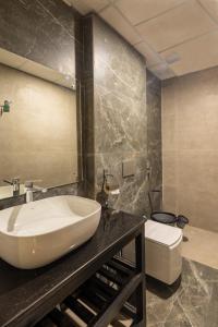 une salle de bain avec un lavabo blanc et des toilettes dans l'établissement Rumuk Boutique Resort - Offbeat escape, à Dhanaulti