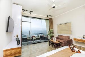 a living room with a couch and a balcony at Rumuk Boutique Resort - Offbeat escape in Dhanaulti +23 photos