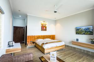 une chambre avec un lit et un canapé dans l'établissement Rumuk Boutique Resort - Offbeat escape, à Dhanaulti