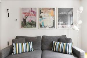 a living room with a couch and four posters on the wall at Fitzrovia Apartment By Morethanstays in London
