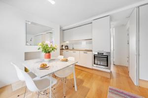 a kitchen and dining room with a table and chairs at Fitzrovia Apartment By Morethanstays in London