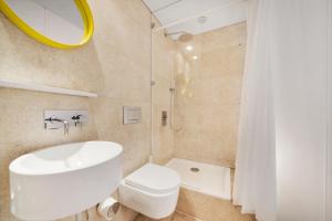 a bathroom with a white toilet and a sink at Fitzrovia Apartment By Morethanstays in London