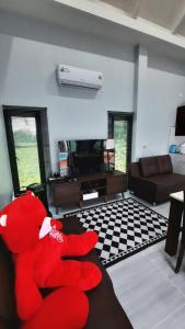 un orsacchiotto rosso seduto su un divano in soggiorno di Love Mountain Pool Villa ประจันตคาม ปราจีนบุรี a Ban Ko Ta Moi 1 altra foto