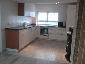 a kitchen with a sink and a stove top oven at Ferienwohnung OT Meersburg in Grasbeuren