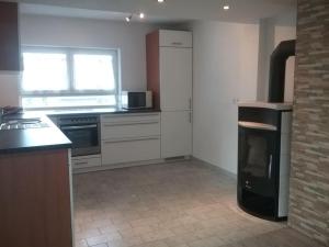 a kitchen with a stove and a refrigerator and a window at Ferienwohnung OT Meersburg in Grasbeuren
