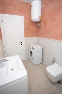 a bathroom with a toilet sink and a washing machine at iunn apartment 2 in Vlorë