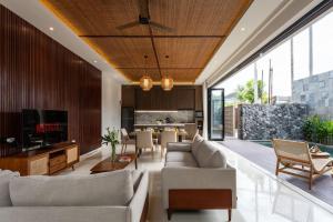 ein offenes Wohnzimmer mit Couch und Fernseher in der Unterkunft BRAND NEW Modern Gem Luxury 3bd Villa in Umalas in Kerobokan