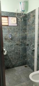a bathroom with a shower with a toilet and a sink at Angel Homestay Paravoor in Alleppey +18 photos