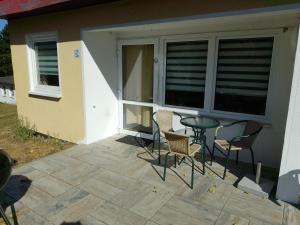 a patio with chairs and a table in front of a house at Ferienhäuser am Mühlenberg in Alt Töplitz