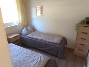 a small room with two beds and a dresser at Ferienhäuser am Mühlenberg in Alt Töplitz
