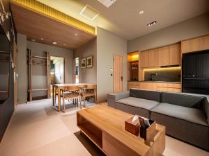 白馬村にあるSki Inn Hakuba, Iwatakeのソファとテーブルのあるリビングルーム