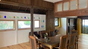 a dining room with a wooden table and chairs at リラシャンティRelashanti in Soni