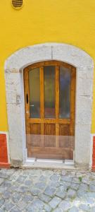 a large wooden door in a yellow building at Nonno Ludovico in Roccasicura