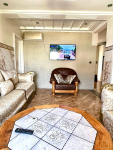 un salon avec un canapé et une télévision au mur dans l'établissement Maison nador corniche, à Nador
